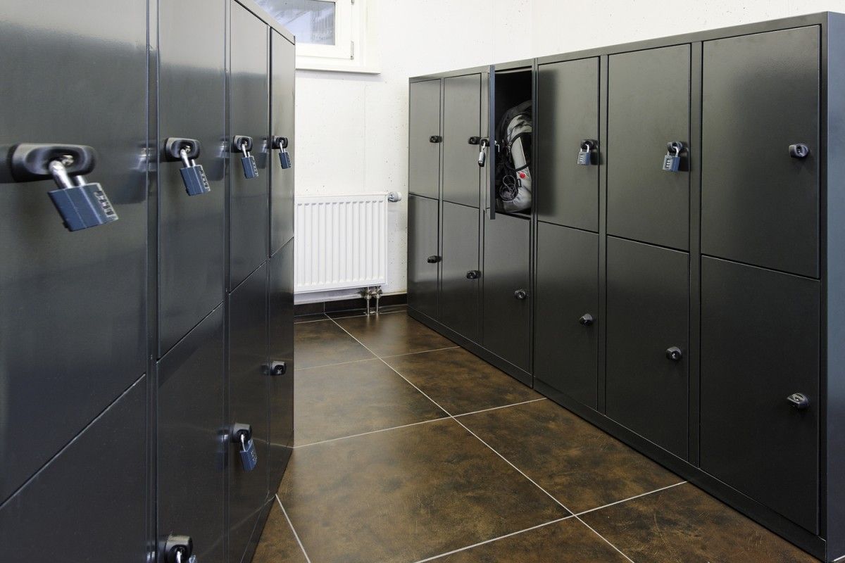 easyHotel luggage room with rows of dark gray metal lockers, one open with a backpack visible, suitable for secure guest storage.