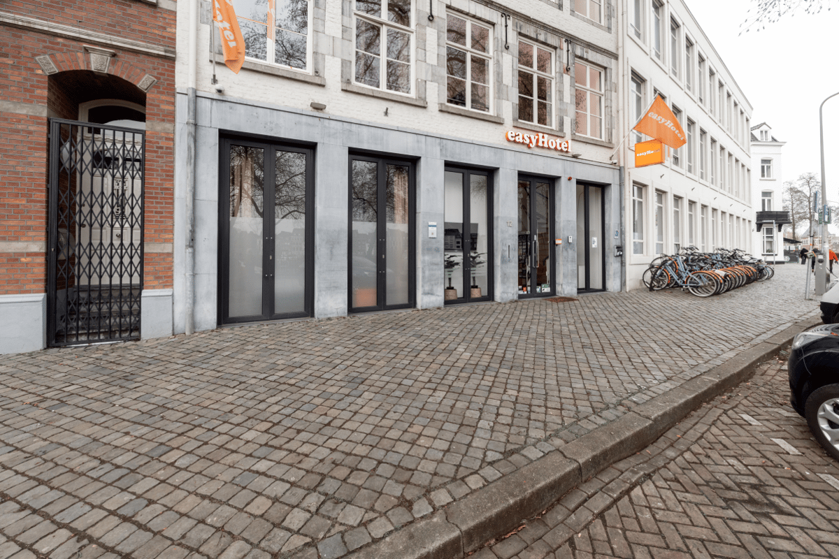 easyHotel Maastricht exterior on a cobblestone street with parked bicycles.
