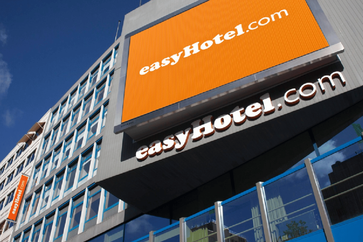 EasyHotel Rotterdam City Centre building exterior on a sunny day, showcasing the large orange easyHotel.com sign and multi-story facade.