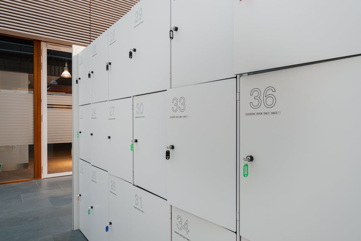 Modern white numbered lockers with 'LOCKERS OPEN ONLY ONCE!' text and keys, providing secure guest storage at easyHotel Amsterdam Zaandam.