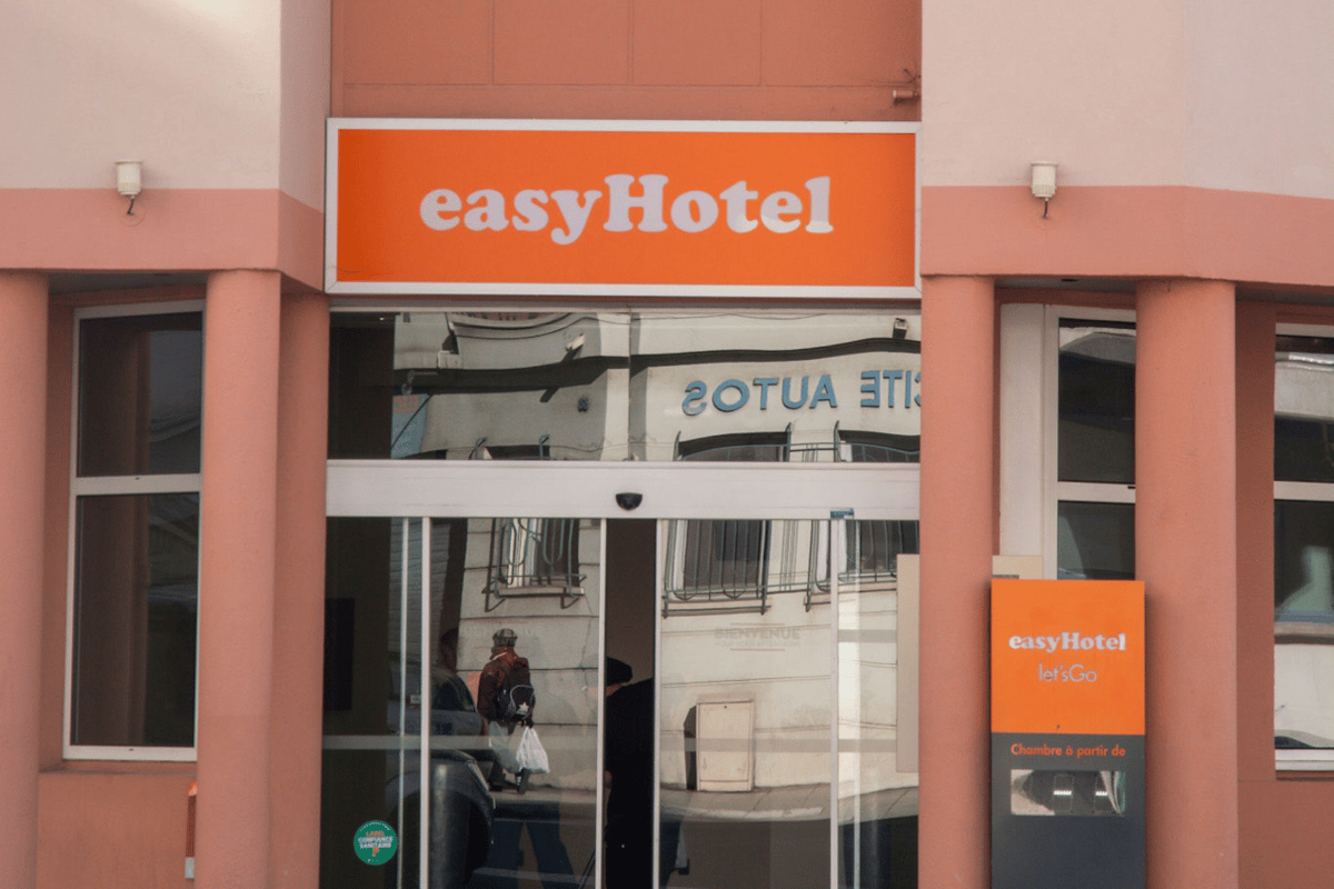 Exterior view of the easyHotel Nice Palais des Congres entrance, featuring a prominent orange easyHotel sign above automated glass doors.