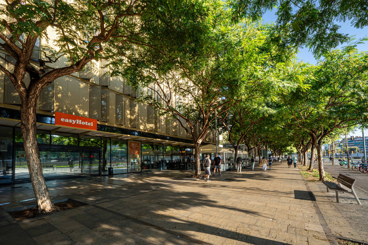 easyHotel Barcelona Fira, street view with trees and pedestrians.