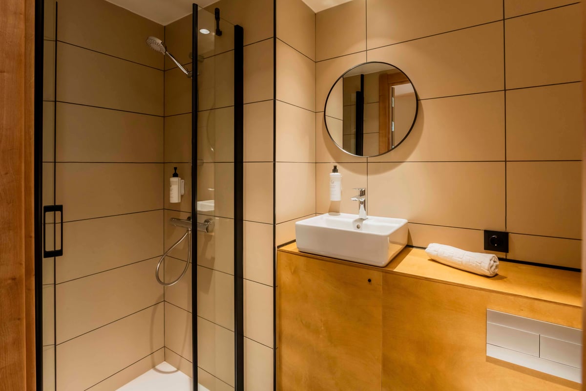 EasyHotel Barcelona La Sagrera bathroom with shower, sink, and mirror.