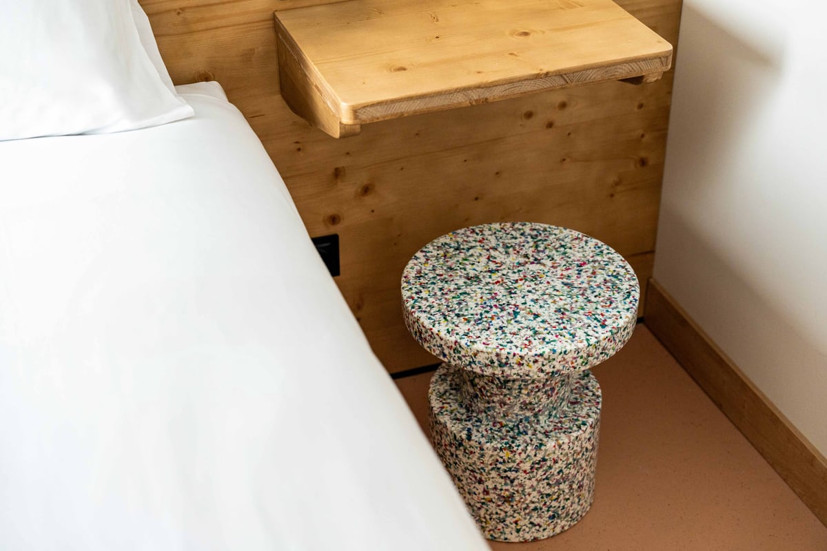EasyHotel Valencia Ciutat Vella double room with white bedding and a multi-colored stool.