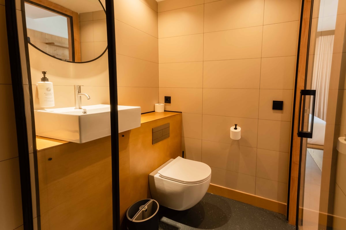 EasyHotel Valencia Ciutat Vella bathroom featuring a white sink, toilet, and tiled walls.