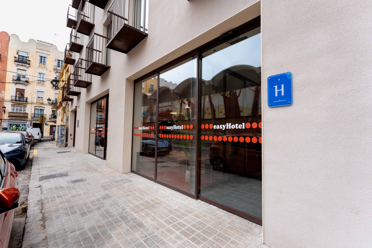 Exterior view of an easyHotel room in Valencia, Spain, featuring a red entrance and signage.