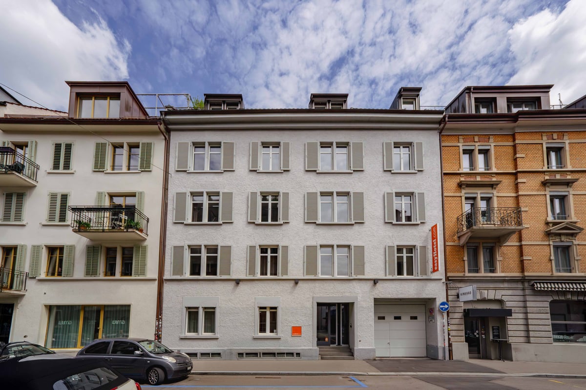EasyHotel Zurich City Centre building facade with multiple windows and shutters under a partly cloudy sky.