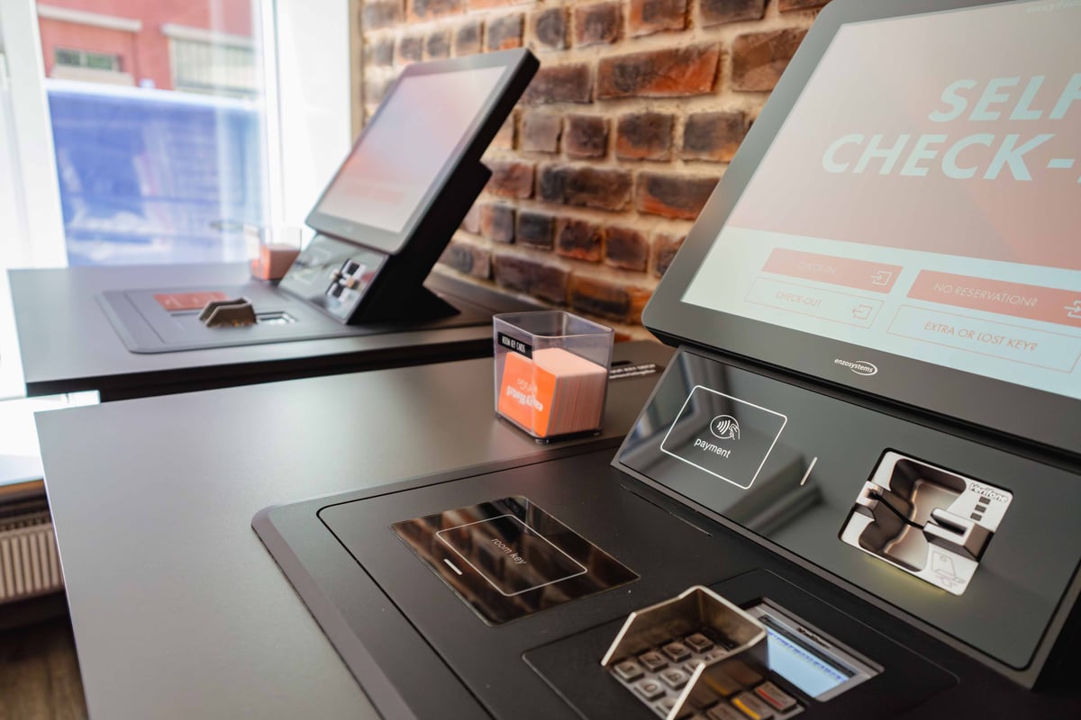 EasyHotel Zurich Limmatplatz self check-in kiosks with payment options and a brick wall background.