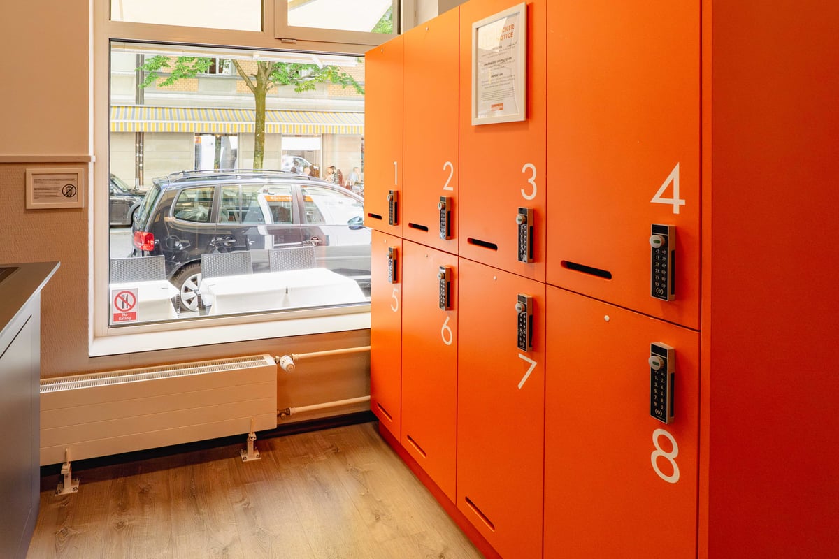 Orange lockers with digital keypads in an easyHotel Zurich Main Reception.