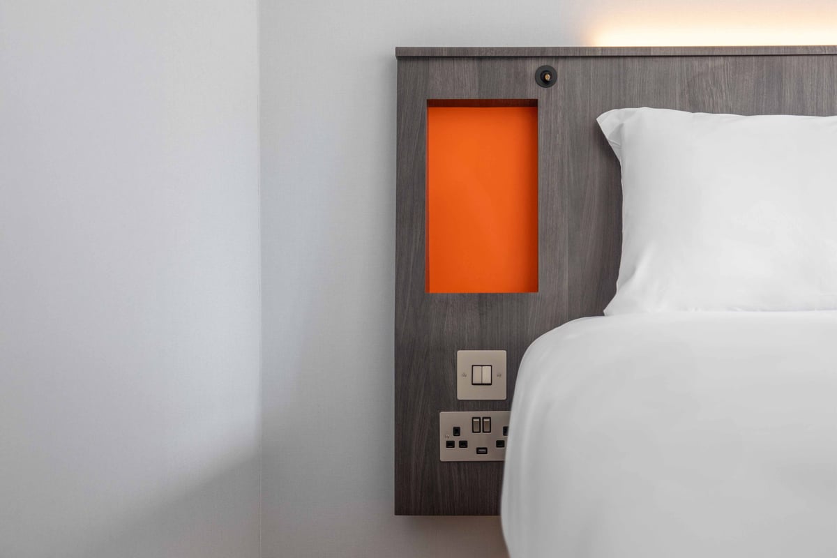 Close-up of headboard with small shelf in headboard, plug sockets and usb sockets