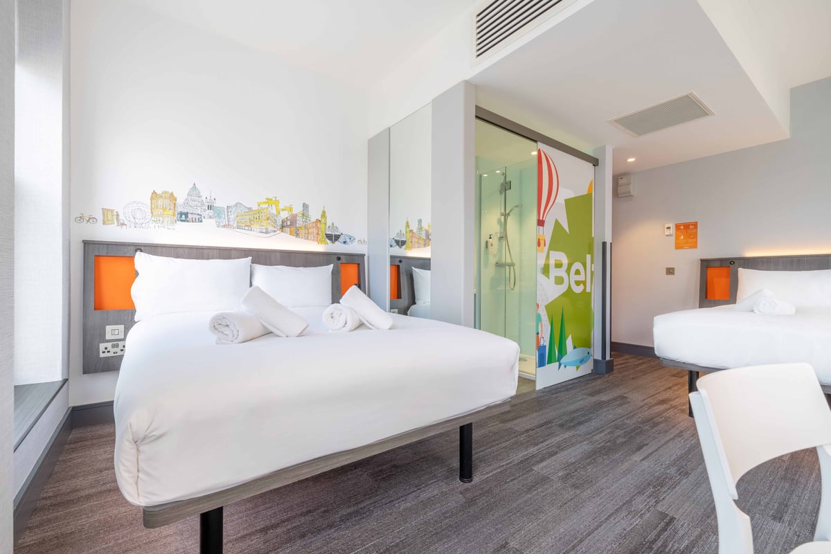 Family quadruple room showing double bed and open bathroom door.