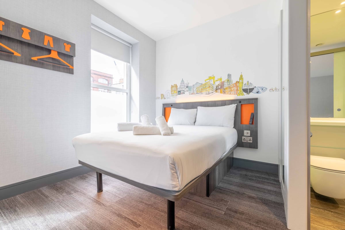 Split view of bed and compact bathroom.