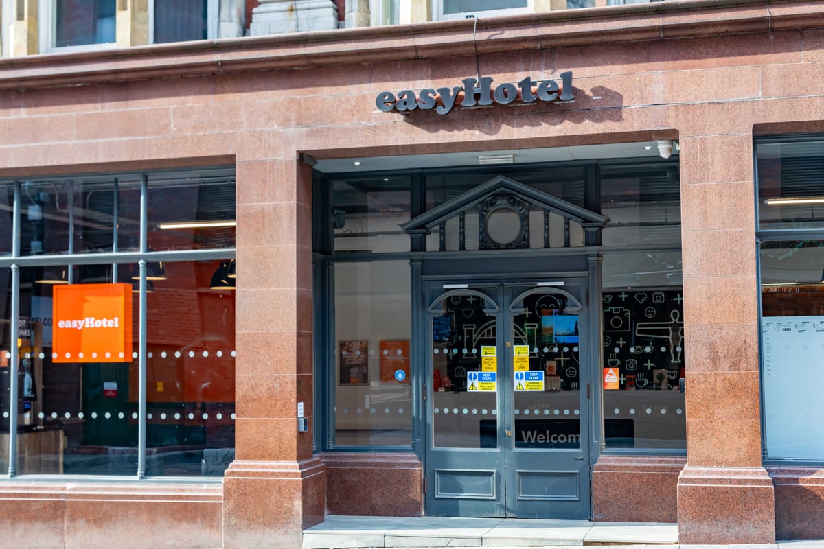 Close-up of easyHotel entrance with glass doors and "Welcome" visible inside.