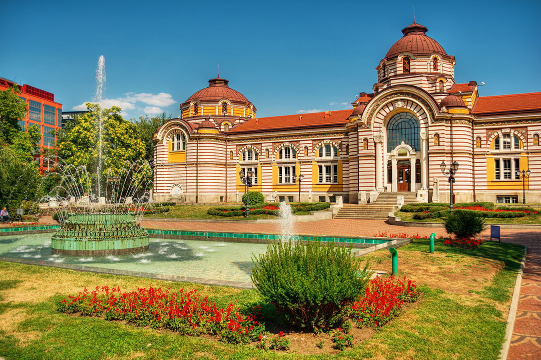 National Museum of Natural History (Central Mineral Baths), Sofia, Bulgaria, with striped facade, red domes, and fountain.
