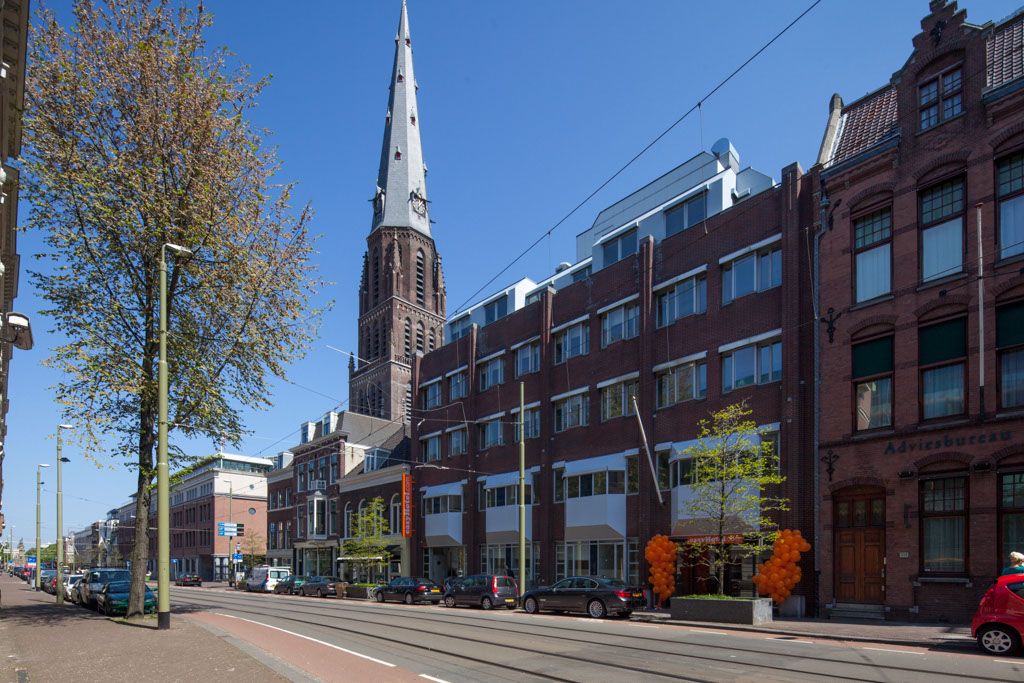 A street in The Hague, The Netherlands with tram lines and a church