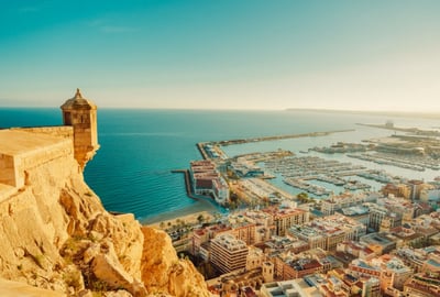 An image of the port in Alicante, with blue skies and a view of the entire city, taken from above.